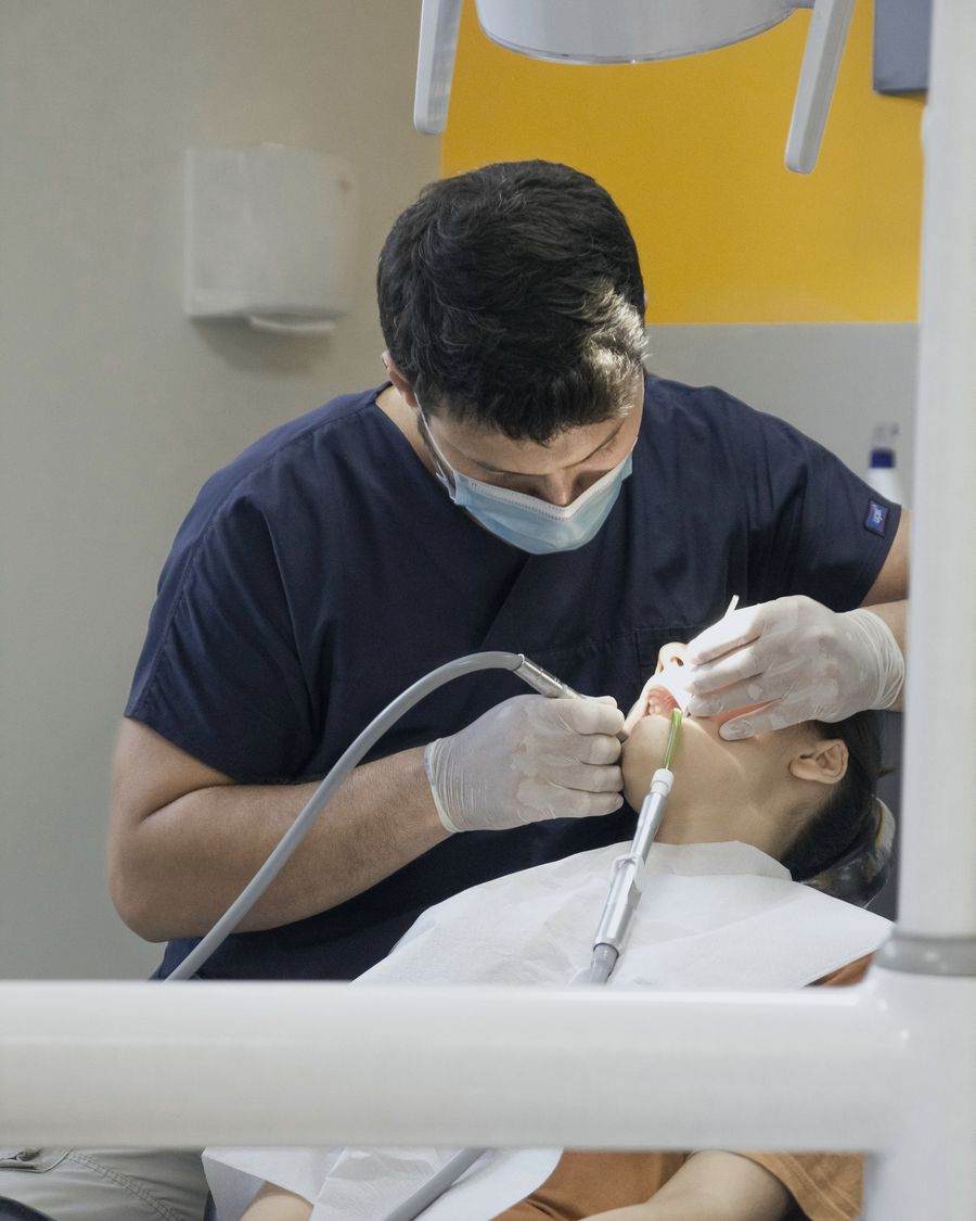 Dentista atendendo paciente no consultório