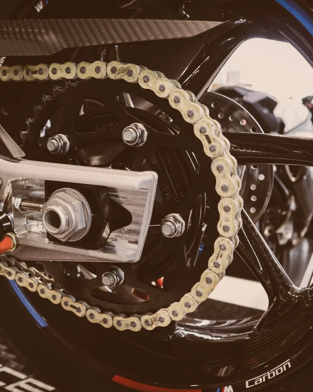Corrente e coroa da roda traseira de uma moto, em close