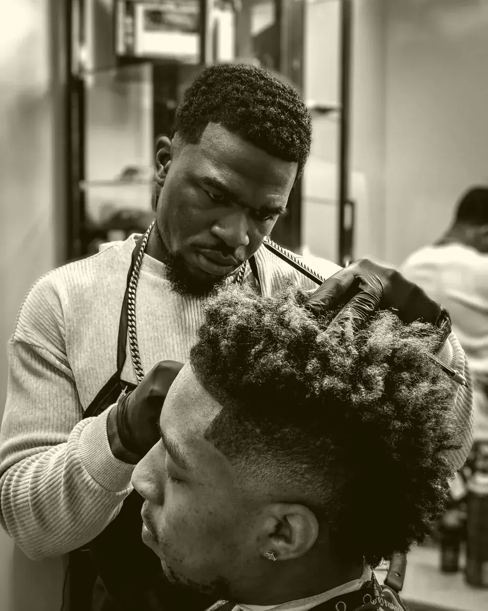 Barbeiro finalizando um corte de cabelo degradê em cliente